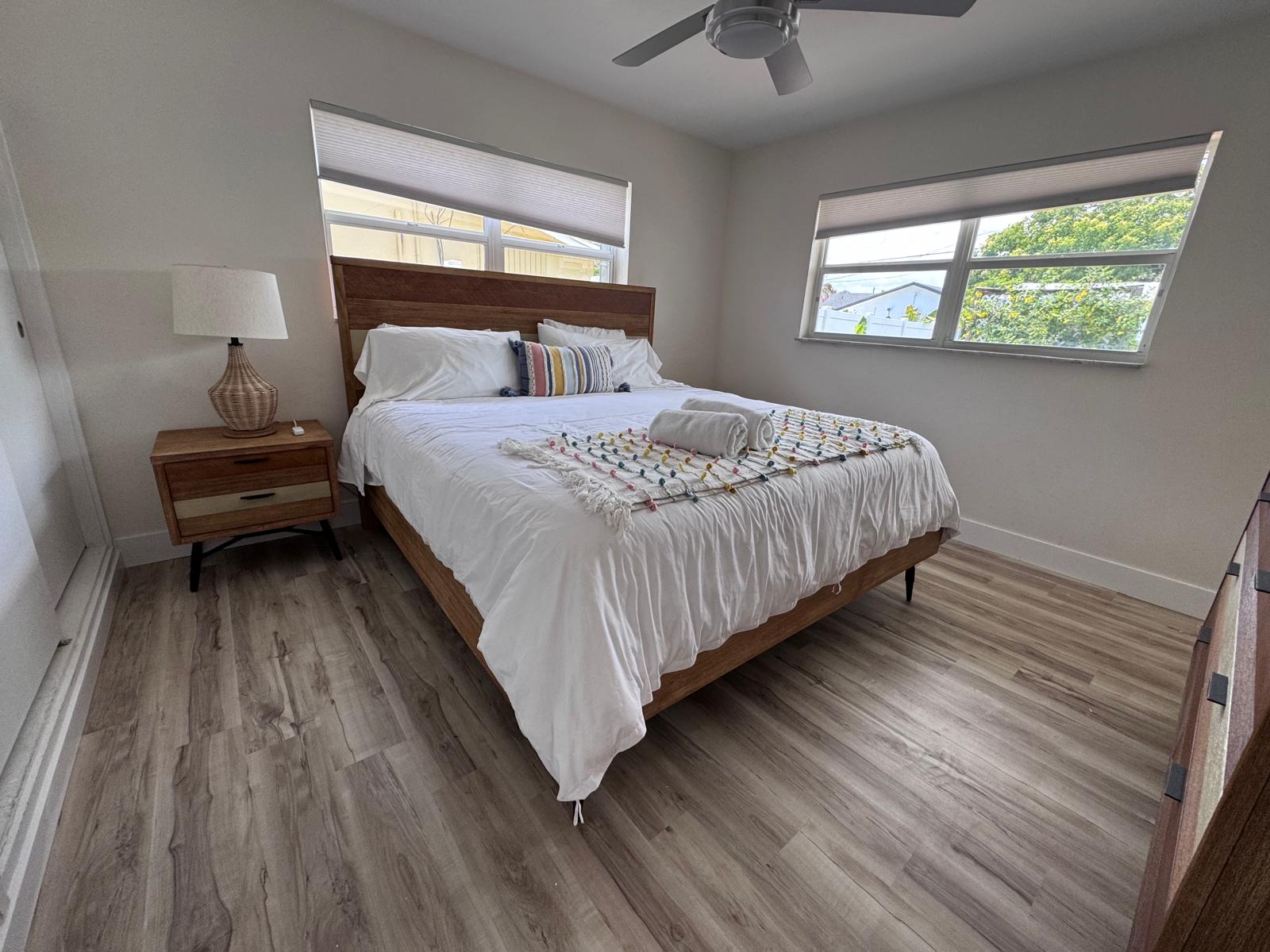Guest bedroom with warm-tone LVP floors and natural light