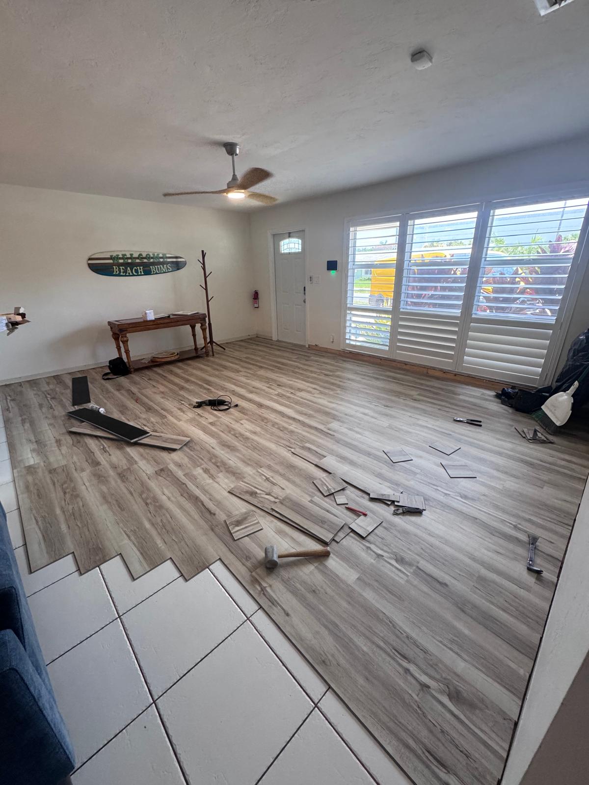 Luxury vinyl plank install in progress over old tile in South Florida living room