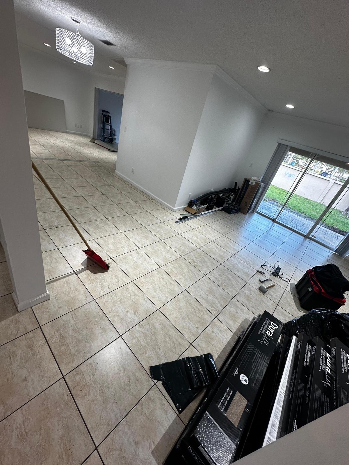 Original cream tile floor before LVP install with DuraLux boxes staged