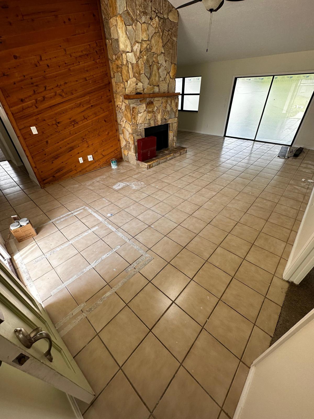 Dated tile and stone fireplace room before flooring transformation